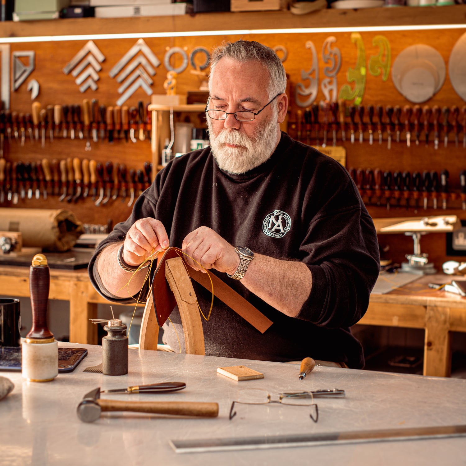 Picture of Nigel Armitage at work in his leatherworkshop.